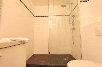 second bathroom with a shower, toilet and sink in a 3-bedroom Paris luxury apartment