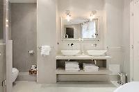 elegant bathrooms with sinks, shower, bathtub and toilet in a 3-bedroom Paris luxury apartment