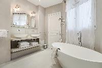 elegant bathrooms with sinks, shower, bathtub and toilet in a 3-bedroom Paris luxury apartment