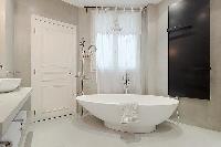 elegant bathrooms with sinks, shower, bathtub and toilet in a 3-bedroom Paris luxury apartment