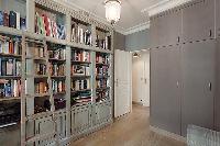 study room with a sofa bed and bookshelves in a 3-bedroom Paris luxury apartment