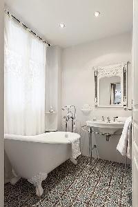 elegant bathrooms with sinks, shower, bathtub and toilet in a 3-bedroom Paris luxury apartment