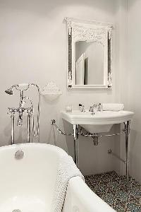 elegant bathrooms with sinks, shower, bathtub and toilet in a 3-bedroom Paris luxury apartment