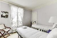 Second Bedroom with two single beds and more closet space in a 2-bedroom Paris luxury apartment