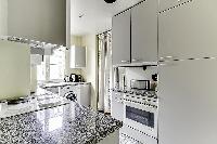 a grand fully-equipped kitchen that is large for Parisian standards in a 2-bedroom Paris luxury apar