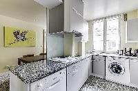 a grand fully-equipped kitchen that is large for Parisian standards in a 2-bedroom Paris luxury apar