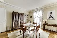 Dining Room with a glass round table and 4 seats in a 2-bedroom Paris luxury apartment