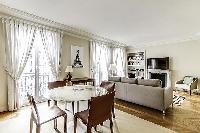 Dining Room with a glass round table and 4 seats in a 2-bedroom Paris luxury apartment