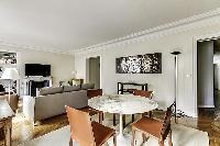 Dining Room with a glass round table and 4 seats in a 2-bedroom Paris luxury apartment