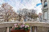 a balcony with flowerpots and amazing street view in paris luxury apartment