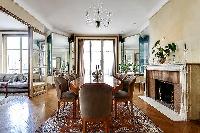 classy dining room for eight with a long table, chandelier, and decorative fireplace with access to 