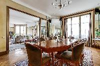 classy dining room for eight with a long table, chandelier, and decorative fireplace with access to 