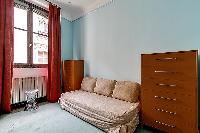 comfortable seats and wooden closet beside the window with drape curtain in paris luxury apartment