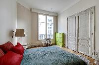 chic bedroom with lamp, bright windows, and drape curtain in paris luxury apartment