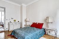 chic bedroom with lamp, bright windows, and drape curtain in a 3-bedroom paris luxury apartment