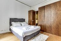 Bedroom with a queen size bed and plenty of closet space in a 1-bedroom Paris flat