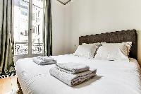 Bedroom with a queen size bed and plenty of closet space in a 1-bedroom Paris flat