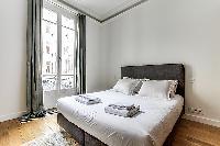 Bedroom with a queen size bed and plenty of closet space in a 1-bedroom Paris flat