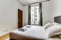 Bedroom with a queen size bed and plenty of closet space in a 1-bedroom Paris flat