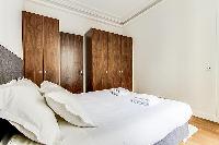 Bedroom with a queen size bed and plenty of closet space in a 1-bedroom Paris flat