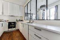 semi-open kitchen view-able by windows  in a 2-bedroom Paris luxury apartment