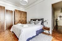 Bedroom with Queen size bed, bedside tables, lamps, and plenty of closets in a 2-bedroom Paris luxur