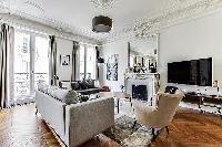 Living room with Haussman ornate ceilings, long French windows, original wooden floors and decorativ