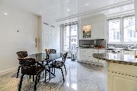 fully equipped modern kitchen with a dining table and 4 seats in a 3-bedroom Paris luxury apartment