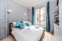 second bedroom with comfortable sleeping amenities and plenty of closets in a 3-bedroom Paris luxury