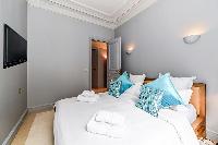 second bedroom with comfortable sleeping amenities and plenty of closets in a 3-bedroom Paris luxury