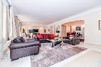 stylish open living area with beautiful dark wooden floors and a big flat screen TV in a 3-bedroom P