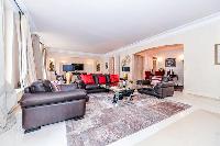 stylish open living area with beautiful dark wooden floors and a big flat screen TV in a 3-bedroom P