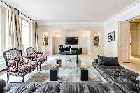 stylish open living area with beautiful dark wooden floors and a big flat screen TV in a 3-bedroom P