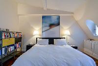 chic bedroom with bookshelves  in a 2-bedroom paris luxury apartment