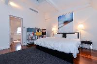 master bedroom with a king size bed, a television, and an en suite bathroom with a tub, shower, and 