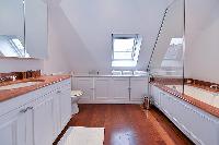 an en suite bathroom with a tub, shower, and a full toilet in paris luxury apartment