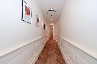 hallway with parquet floor and work of arts hanged on the wall in a 3-bedroom paris luxury apartment