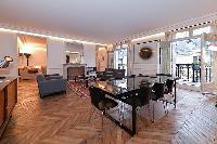elegant dining table with 8 seats,living area, French windows with balcony, and parquet floor in par