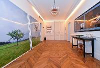 hallway with parquet floor and work of arts hanged on the wall in a 3-bedroom paris luxury apartment