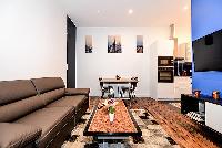 modern and chic living area with a comfortable sofa bed, a huge HD Television, a lovely carpet, and 