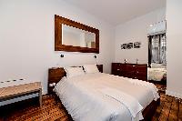 modern master bedroom with a king-sized bed, ample storage space, a safe, and a television in a 1-be