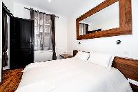 modern master bedroom with a king-sized bed, ample storage space, a safe, and a television in a 1-be