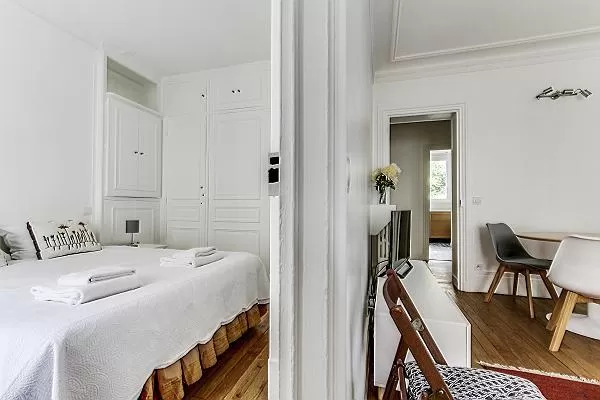 bedroom with a queen size bed with access to the living area in paris luxury apartment