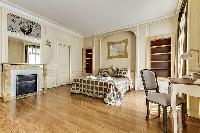 bedroom  with queen-sized bed, varying duvet colors and room wall decals in a 4-bedroom Paris luxury