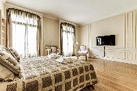 bedroom  with queen-sized bed, varying duvet colors and room wall decals in a 4-bedroom Paris luxury
