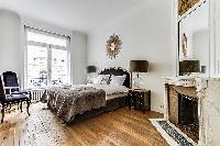 bedroom  with queen-sized bed, varying duvet colors and room wall decals in a 4-bedroom Paris luxury