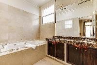 elegant en-suite bathroom with bathtub, lavatory, and full toilet in a 4-bedroom Paris luxury apartm