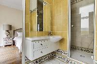 elegant en-suite bathroom with bathtub, lavatory, and full toilet in a 4-bedroom Paris luxury apartm