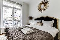 bedroom  with queen-sized bed, varying duvet colors and room wall decals in a 4-bedroom Paris luxury