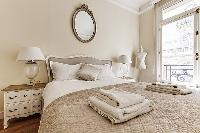 bedroom  with queen-sized bed, varying duvet colors and room wall decals in a 4-bedroom Paris luxury